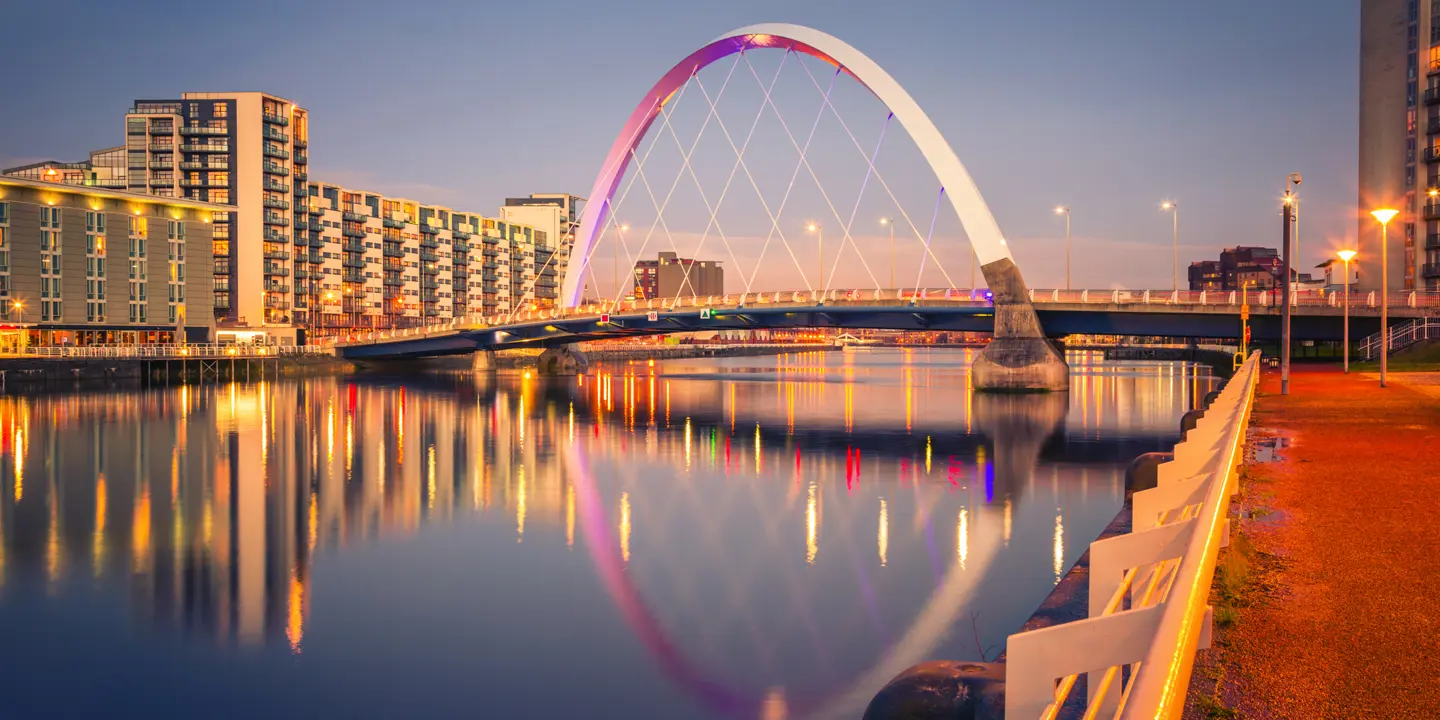 A bridge spanning a body of water alongside towering buildings.