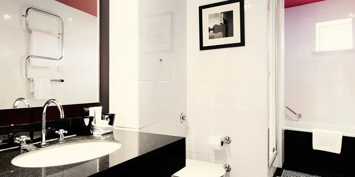 Bathroom featuring a bathtub, sink, and mirror.
