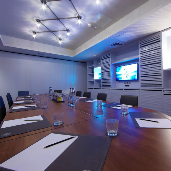 Conference room featuring a spacious table and a sleek flat-screen TV.
