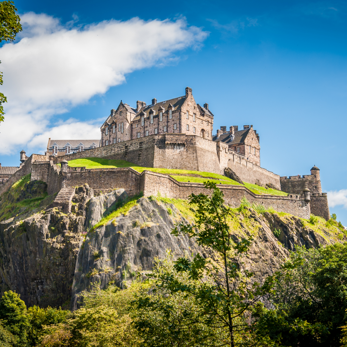 A castle atop a mountain, enveloped by lush trees.