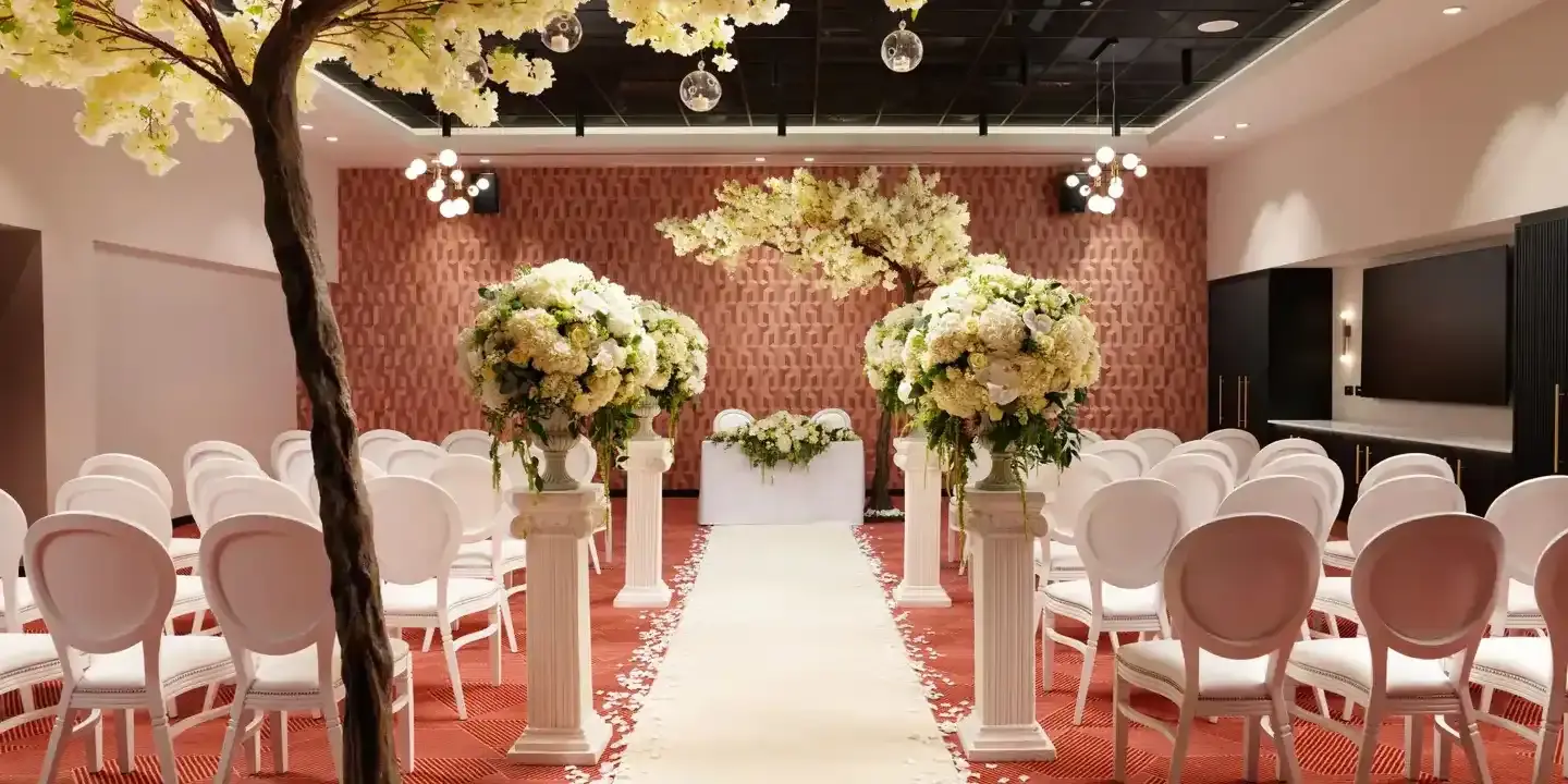 An elegantly decorated room adorned with pristine white chairs and delicate white flowers.