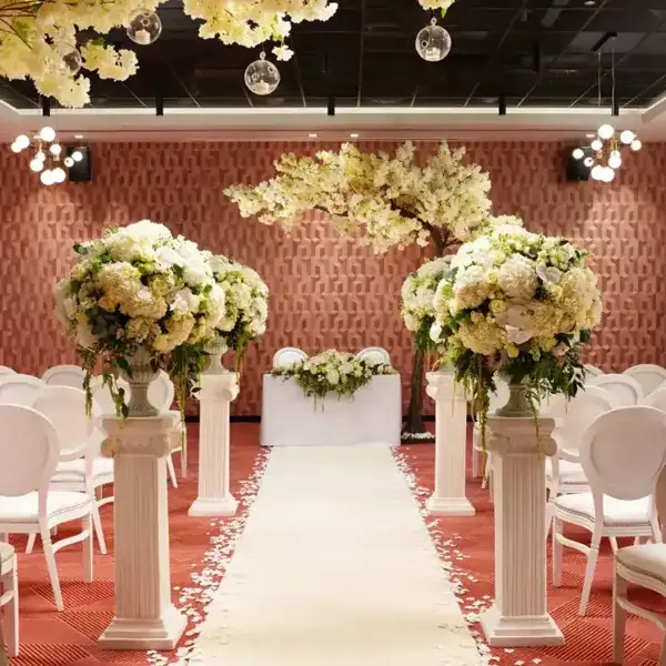 An elegantly decorated room adorned with pristine white chairs and delicate white flowers.