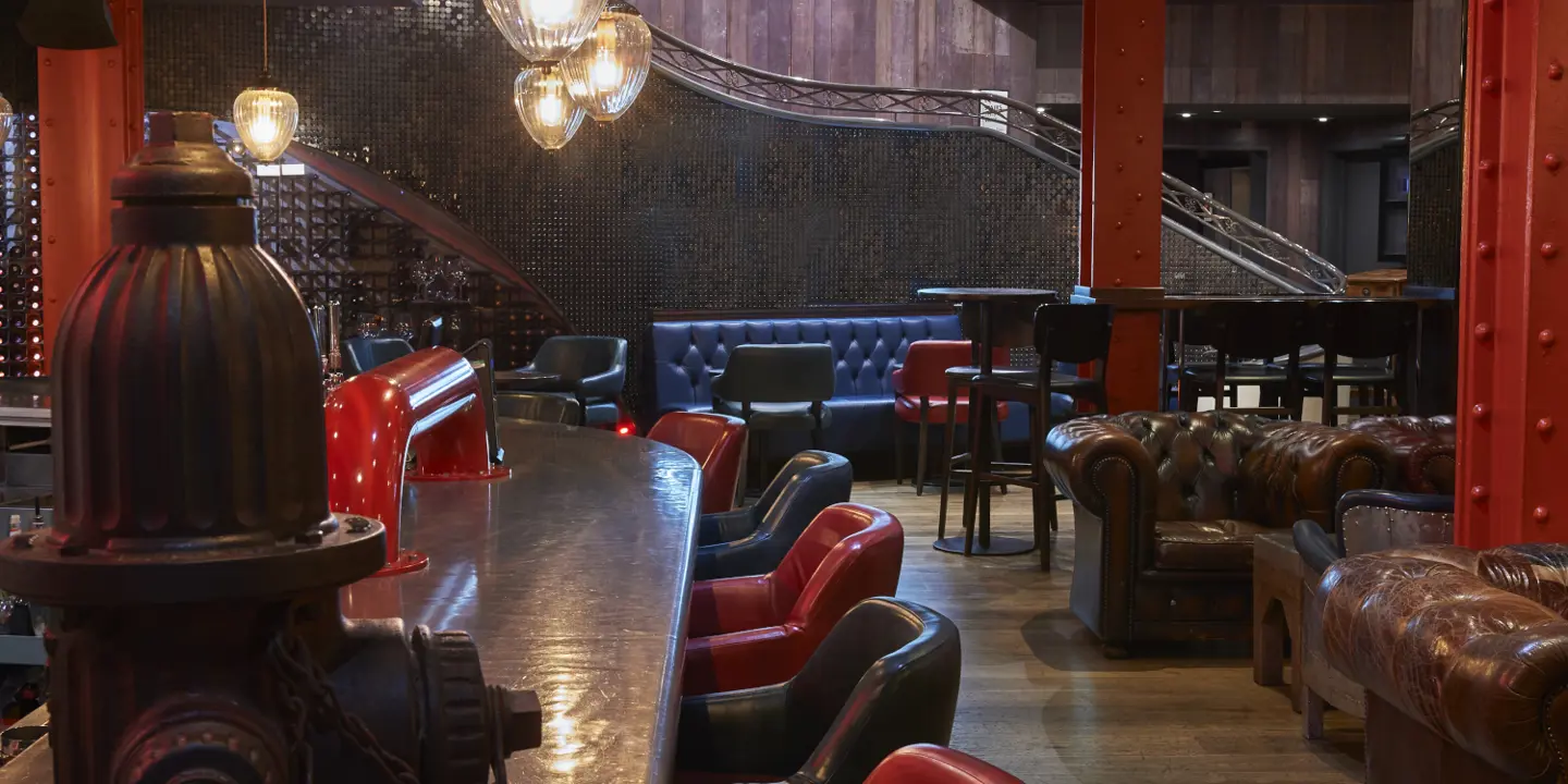 A well-furnished room with a variety of furniture and a stylish bar.