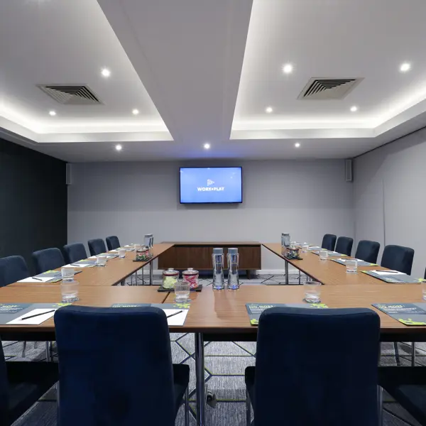 Conference room featuring blue chairs and a flat-screen TV.