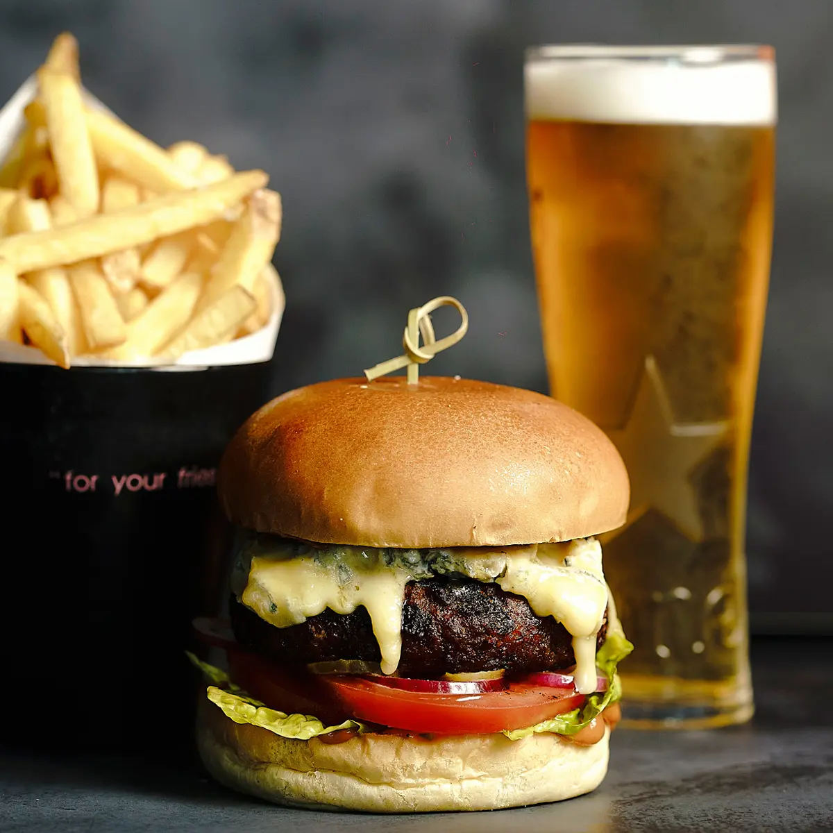 Cheeseburger served with fries and a pint of beer.