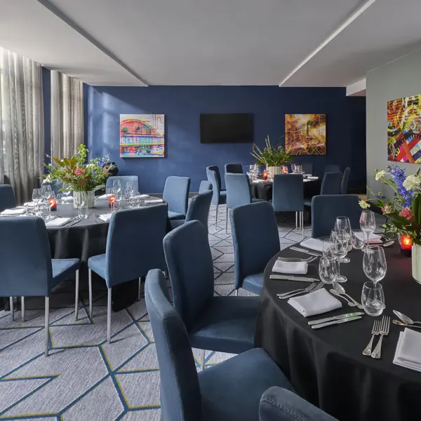 A beautifully arranged table for a formal dinner adorned with elegant candles and exquisite flowers.