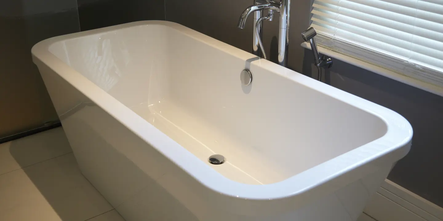 White bathtub positioned in a bathroom adjacent to a window.