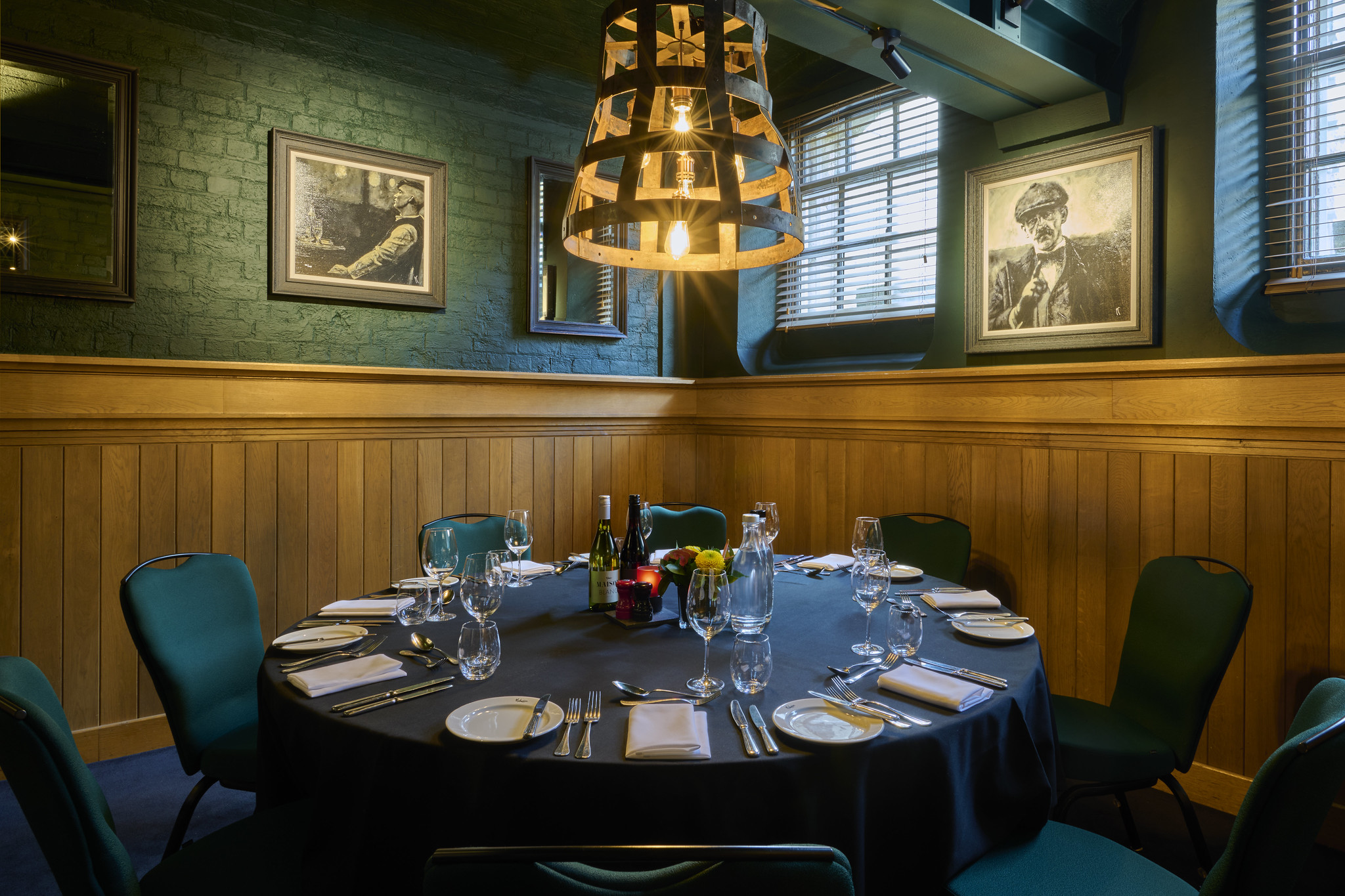 A dining room featuring a table, chairs, and bottles of wine.