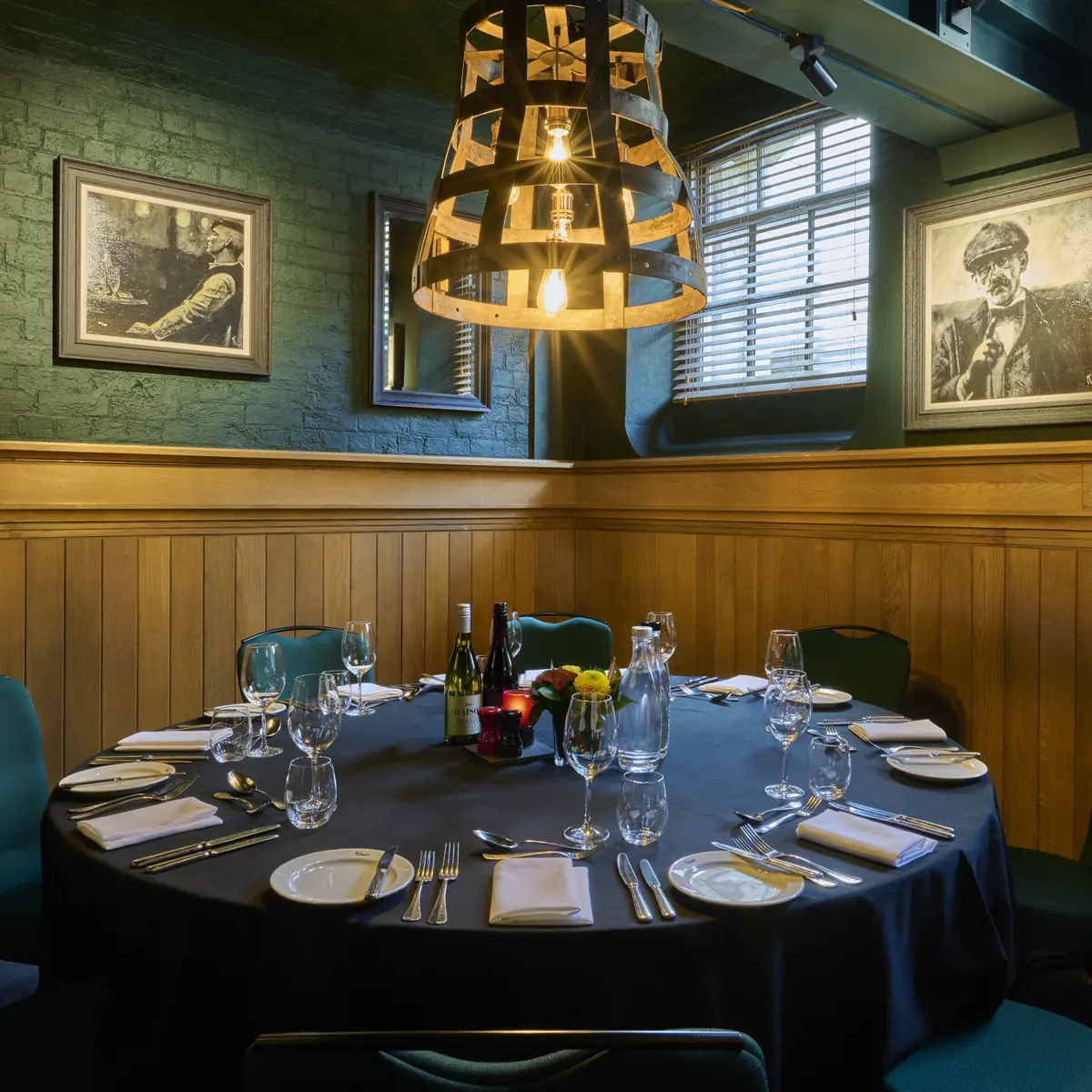 A dining room featuring a table, chairs, and bottles of wine.