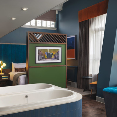 A spacious room with a large bed and two bathtubs.