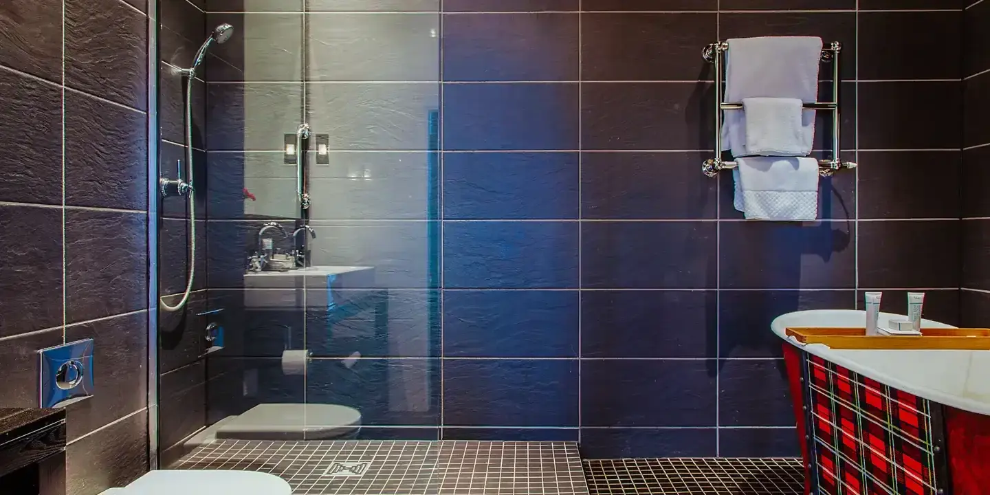 A bathroom featuring a shower, toilet, and sink.