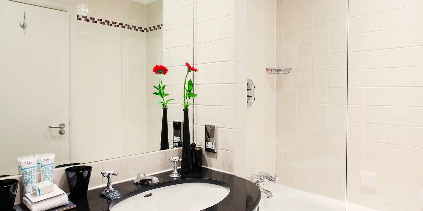 A bathroom featuring a sink, mirror, and bathtub.