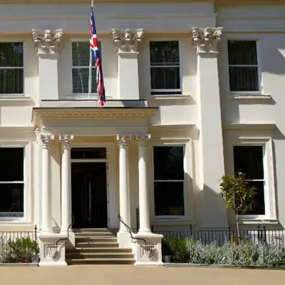 A spacious white building featuring a flag atop.