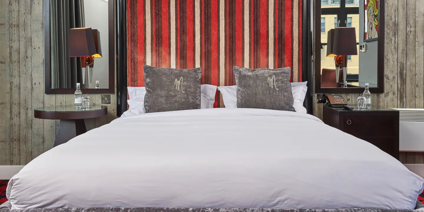 A bed featuring a headboard with red and white stripes.