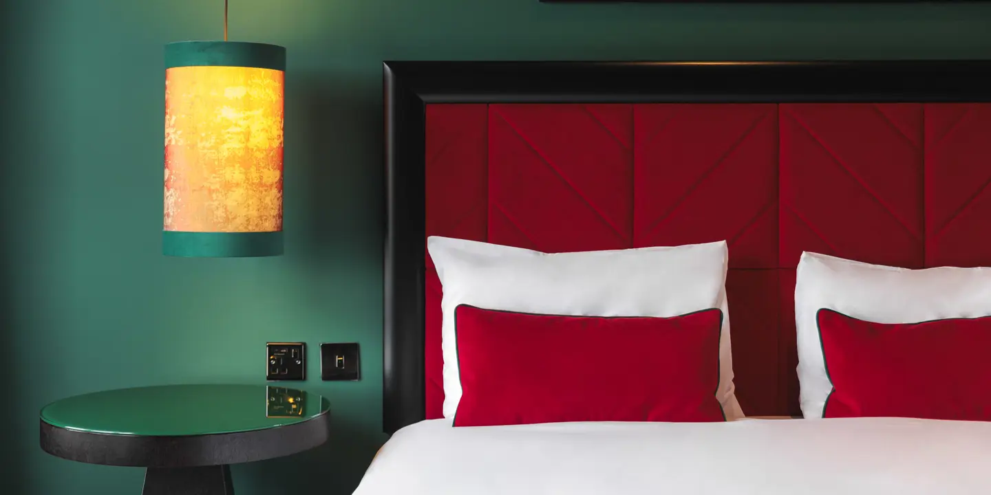 A comfortable bed and a stylish bed side table and light.