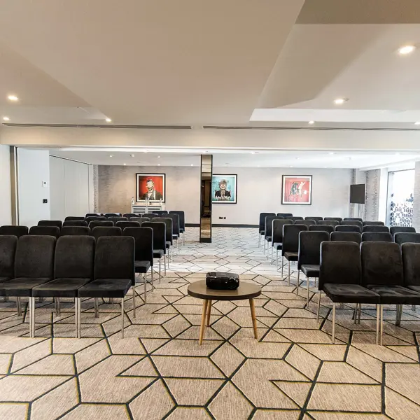 A conference room with rows of seats and a projector