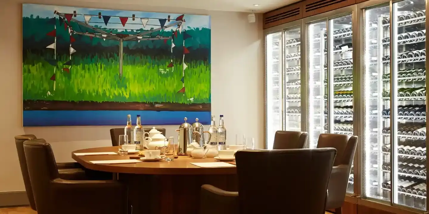 Dining room table with chairs and a painting on the wall