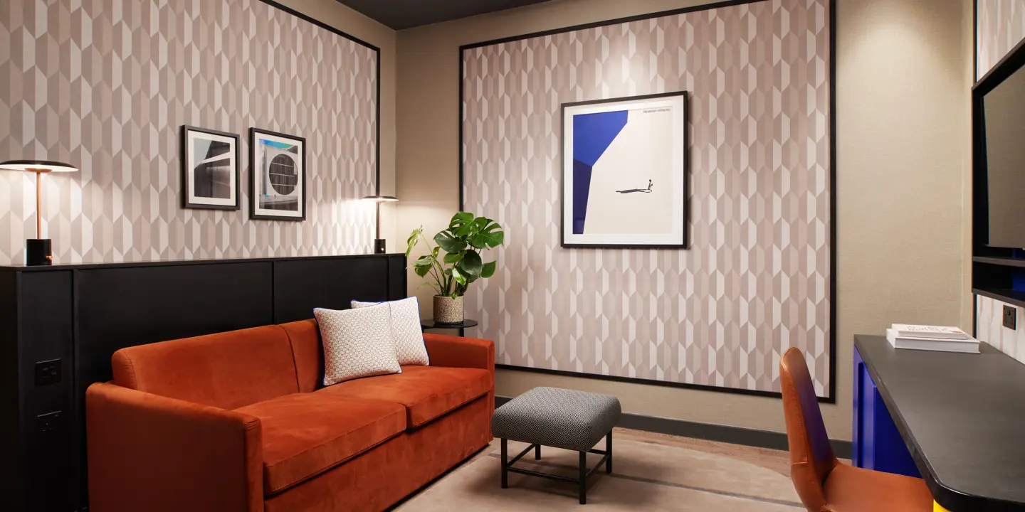 A well-furnished room featuring an orange sofa and desk.