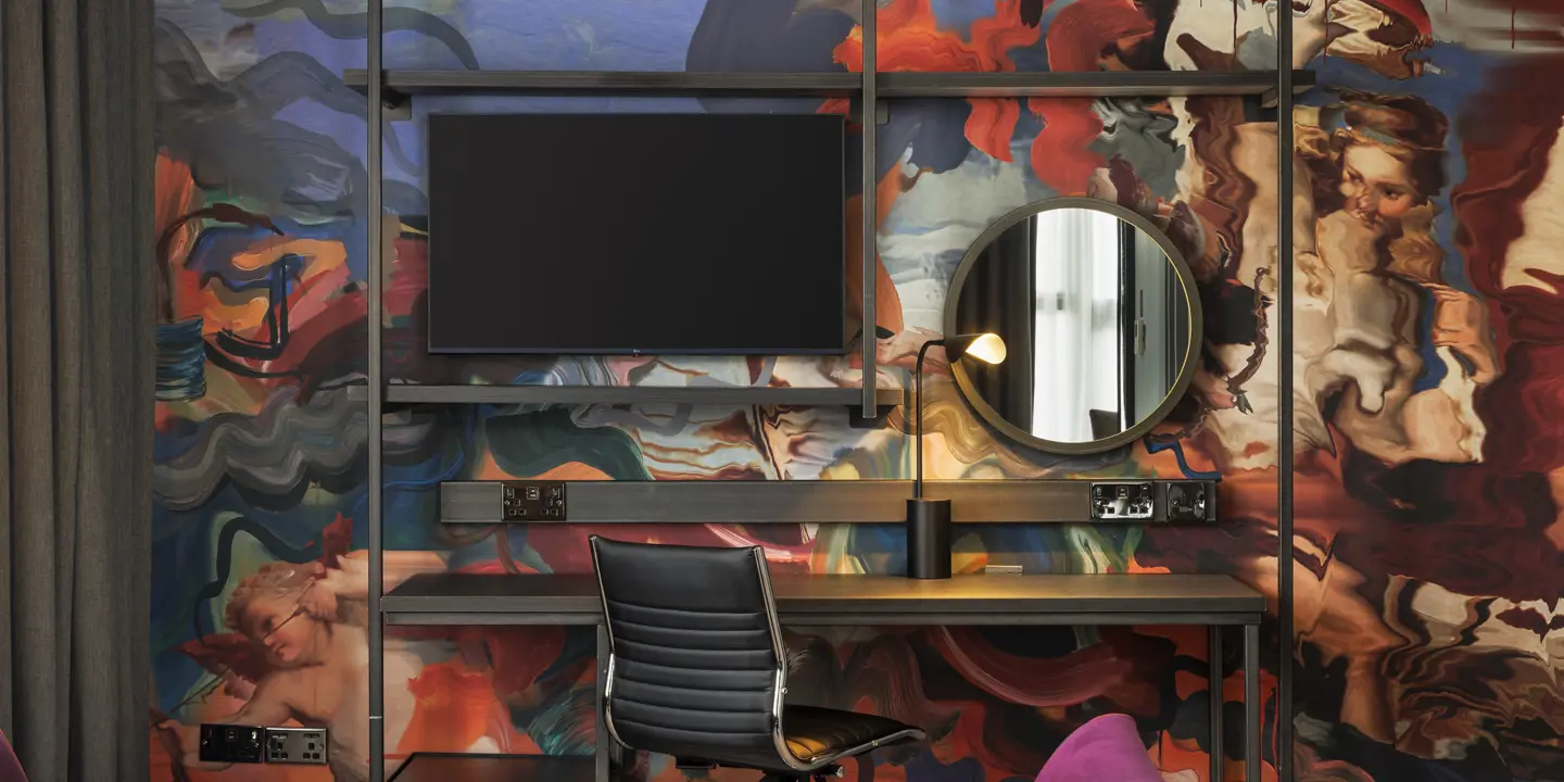 Stylish desk, chair, wall-mounted TV and comfy sofa