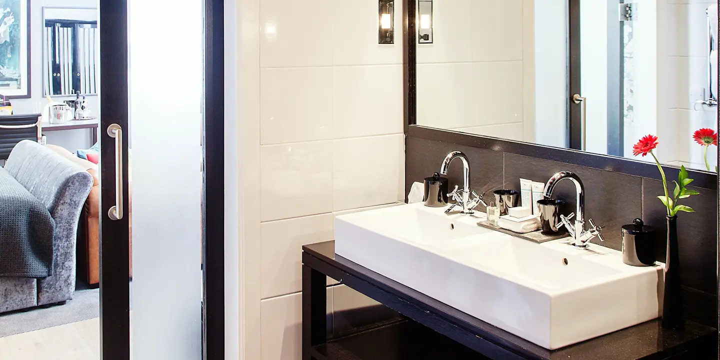 Bathroom featuring dual sinks and a mirror.