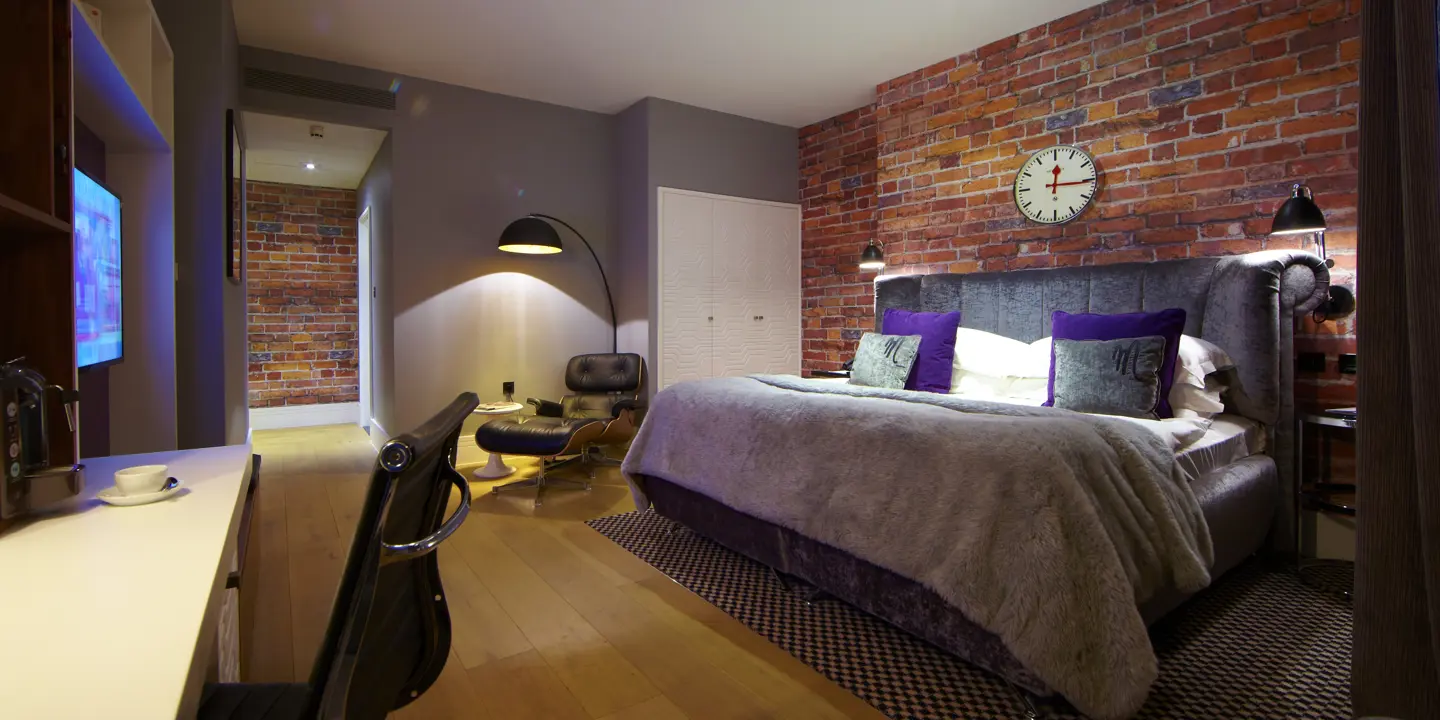 Bedroom featuring a brick wall and a bed.