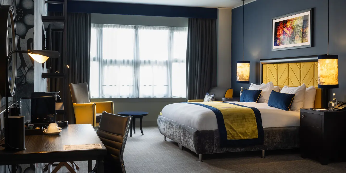 Luxurious comfy bed, stylish chair and desk in spacious room