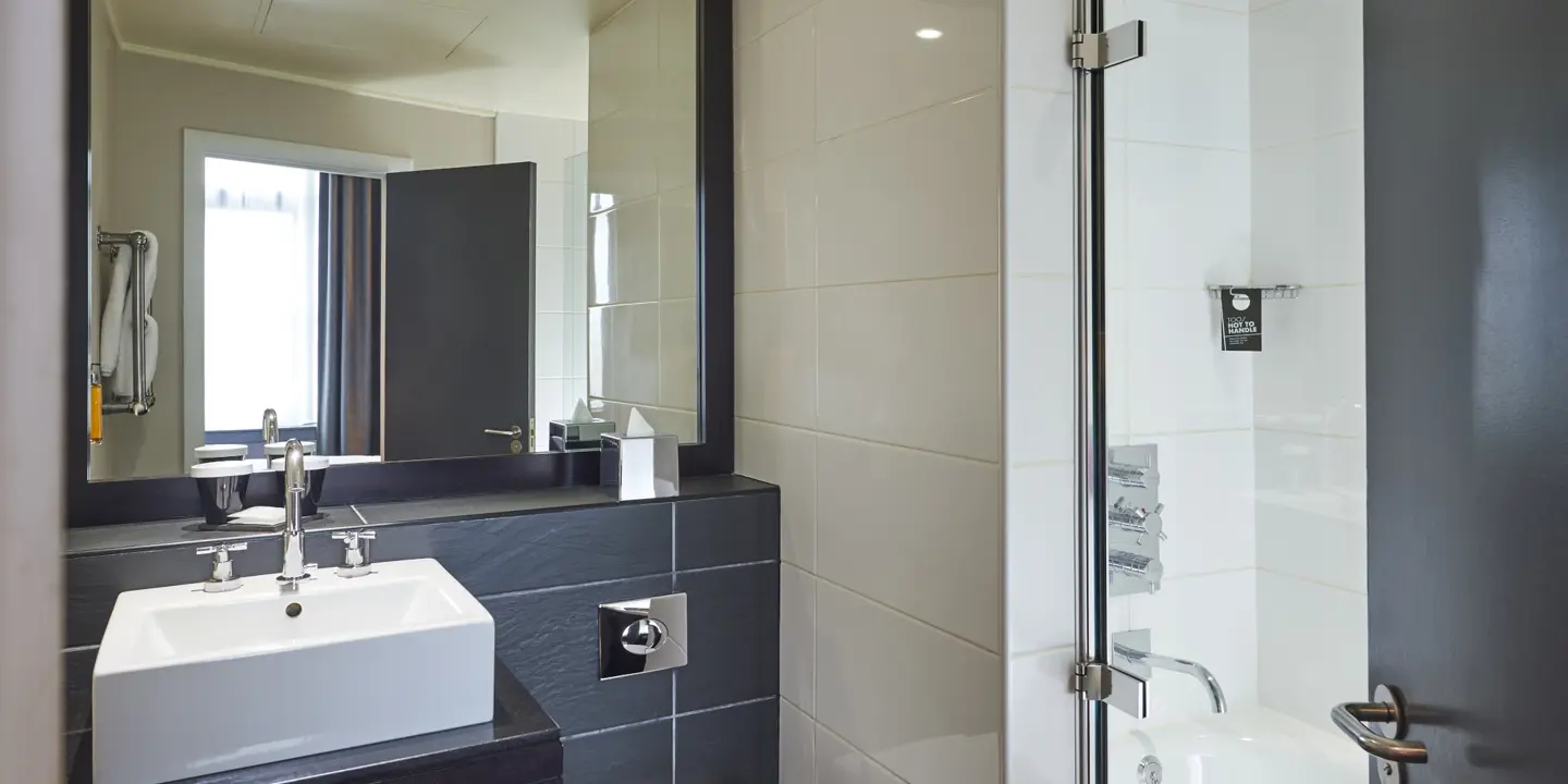 Bathroom featuring a toilet, sink, and shower.