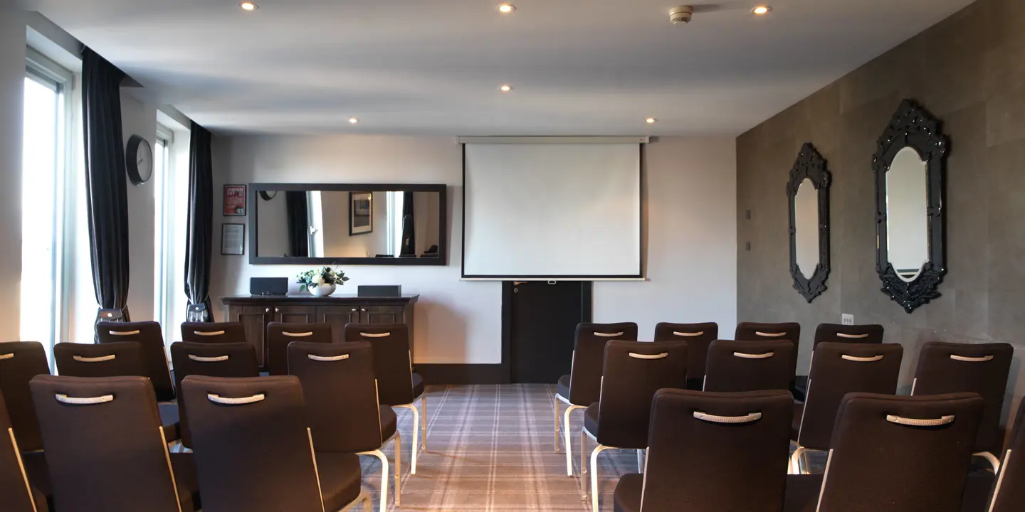 Malmaison Aberdeen Rubislaw conference room with chairs arranged in a seminar format facing a projector screen. Several mirrors adorn the walls.