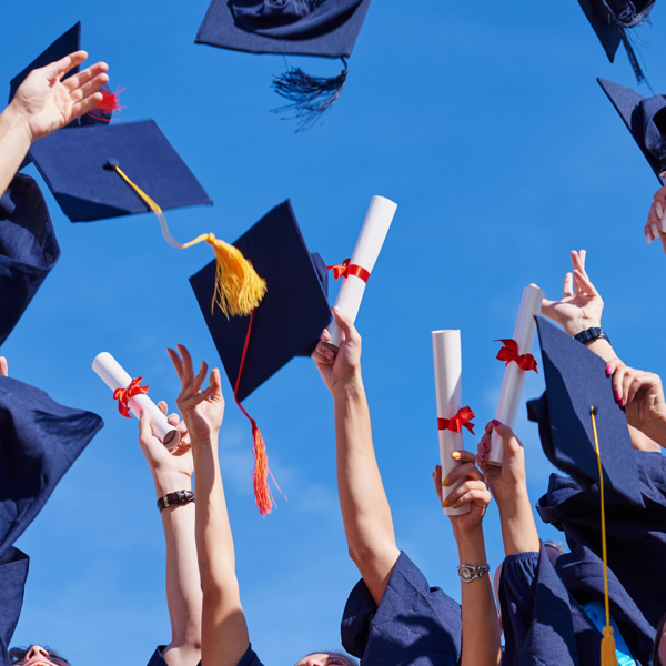Graduates joyfully throwing their caps in celebration.