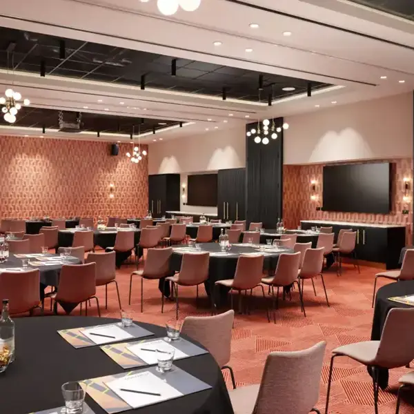 Spacious conference room featuring tables and chairs.