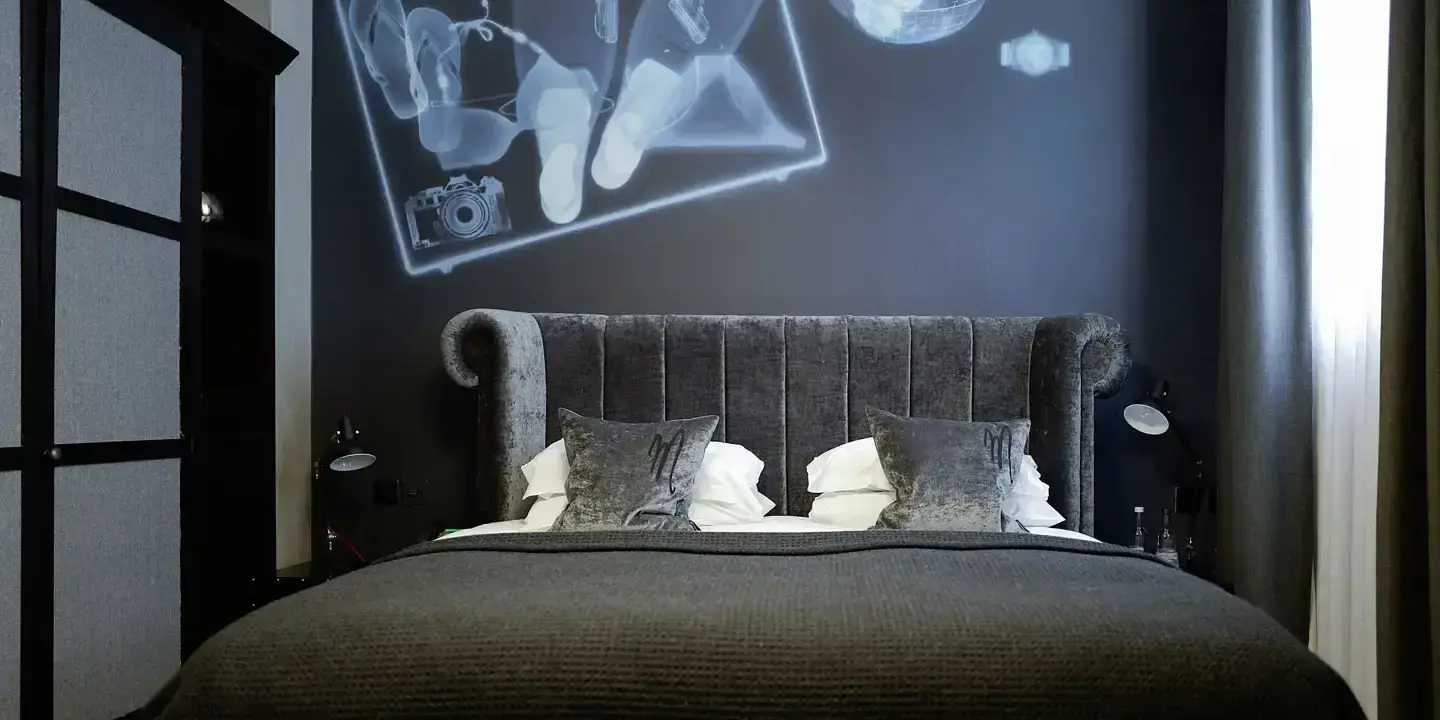 Bed in a room with a black wall.