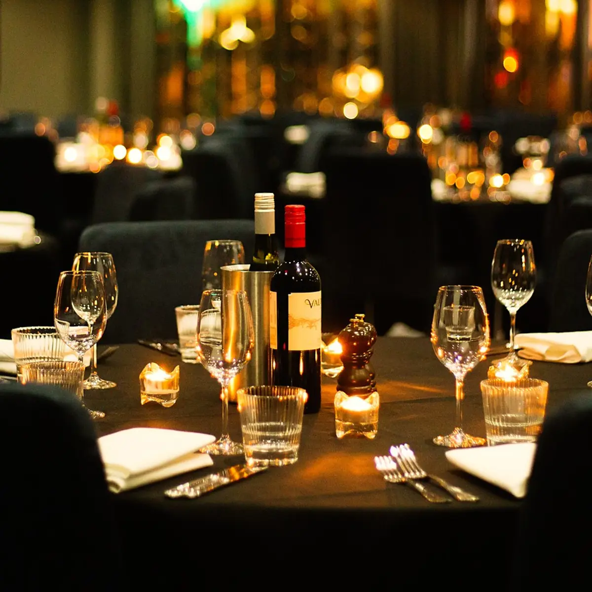 A table adorned with wine glasses and bottles of wine.