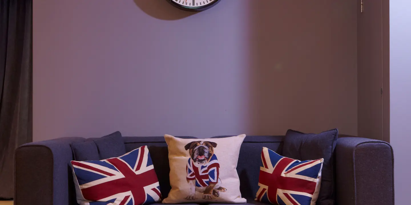 Living room featuring a comfortable couch and a wall-mounted clock.