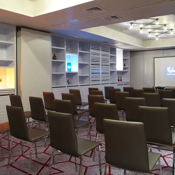 Conference room featuring chairs and a projector screen.