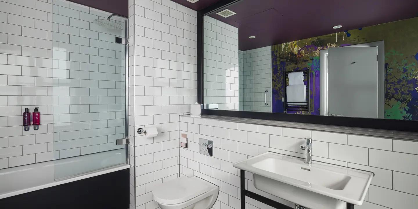 A bathroom featuring a toilet, sink and shower.