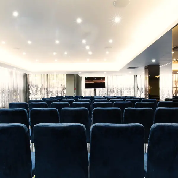 A room adorned with blue chairs and a sleek flat screen television.