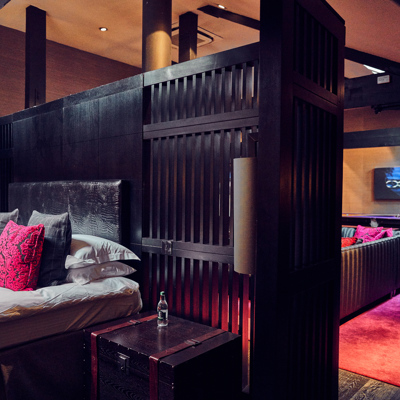 A bedroom with a comfortable bed with a black wooden headboard.