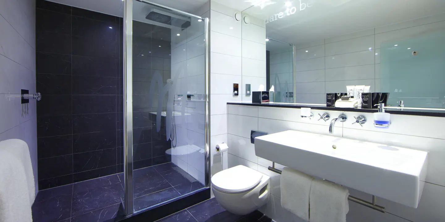 A bathroom featuring a walk-in shower adjacent to a toilet.