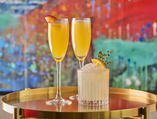 Two garnished cocktails on a marble table