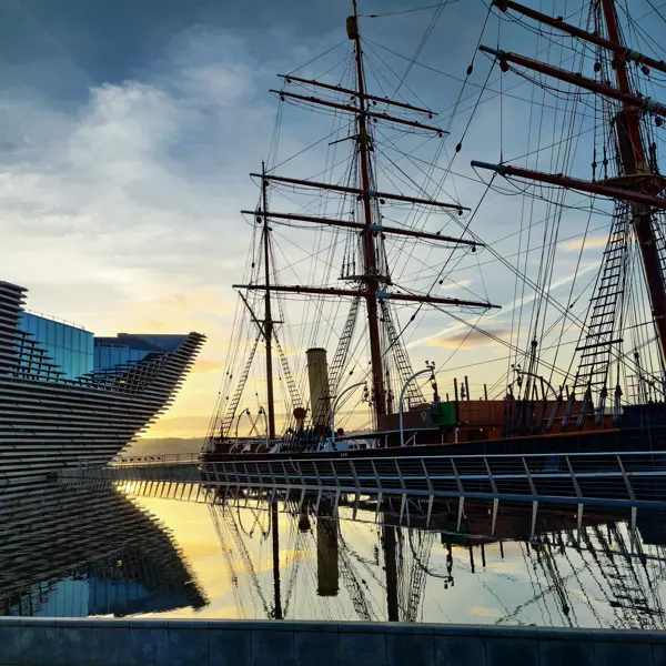 A majestic tall ship docked beside a serene body of water.