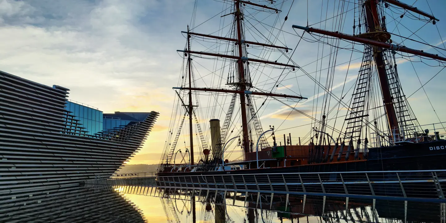 A majestic tall ship docked beside a serene body of water.