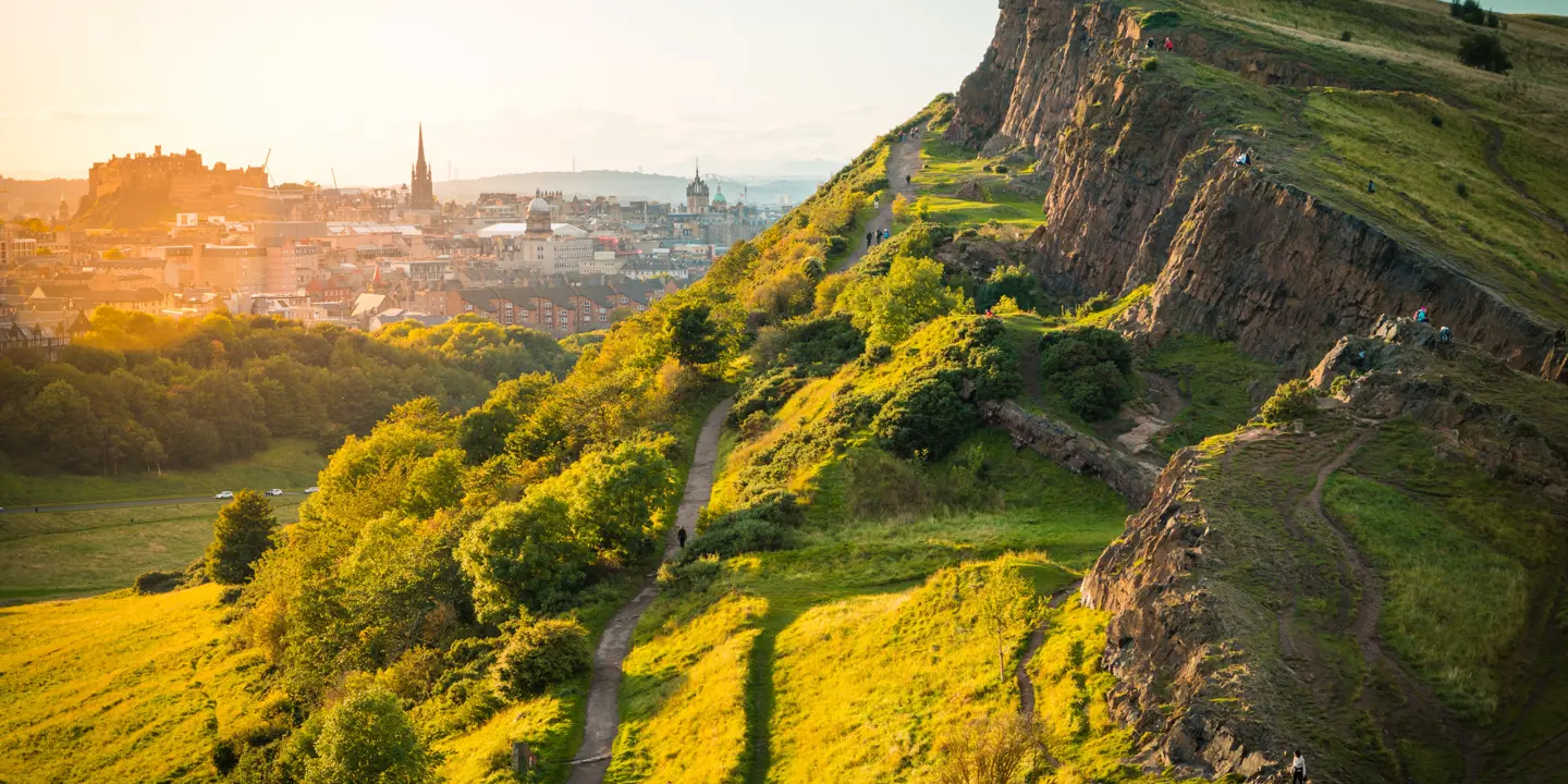 Panoramic view of Edinburgh cityscape from a hilltop.