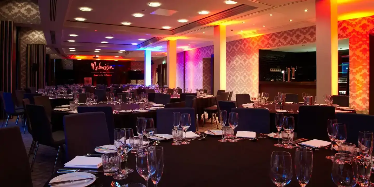 An elegantly arranged dining area with tables and chairs set for a meal.