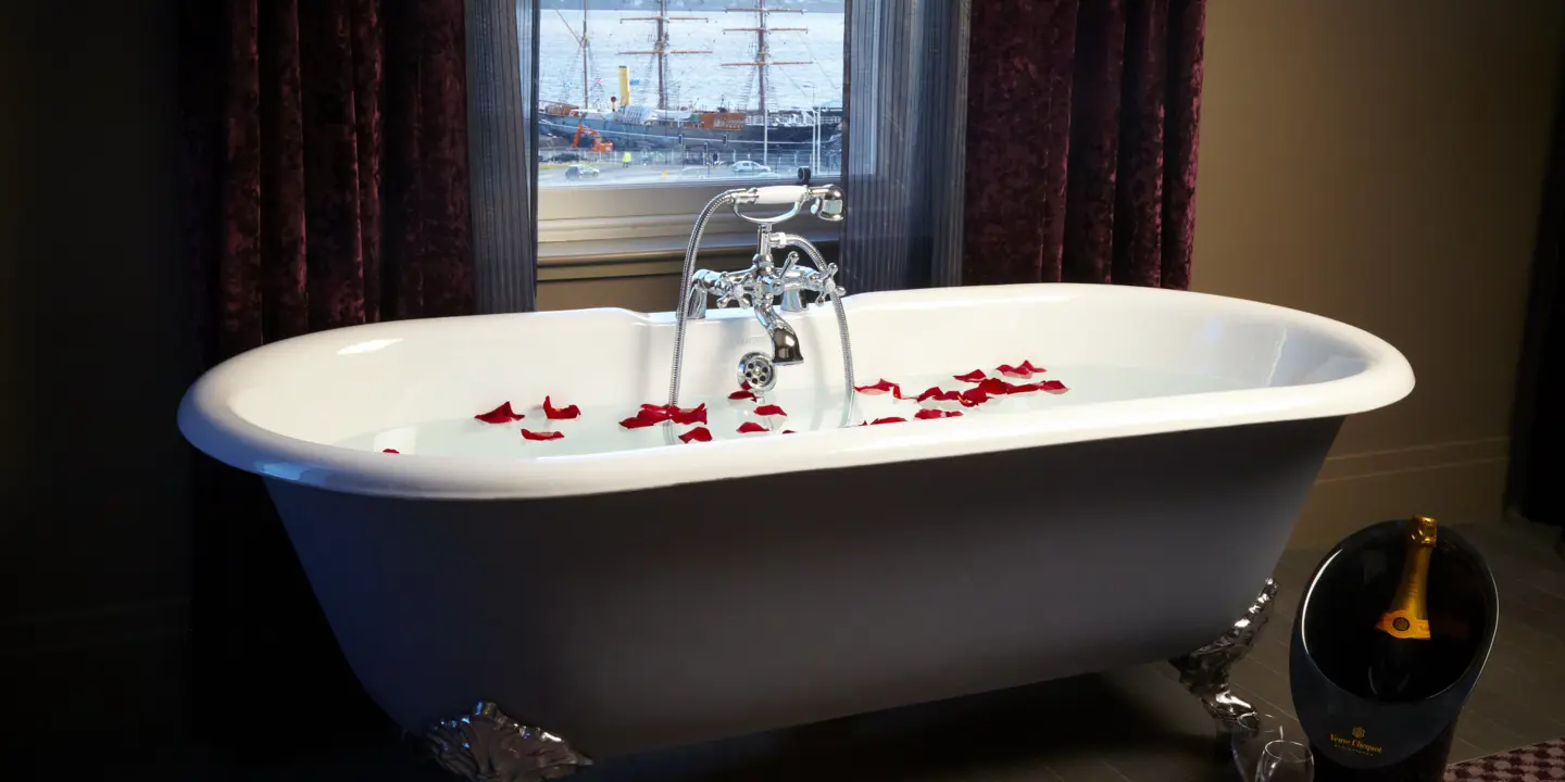Bathtub decorated with red petals.