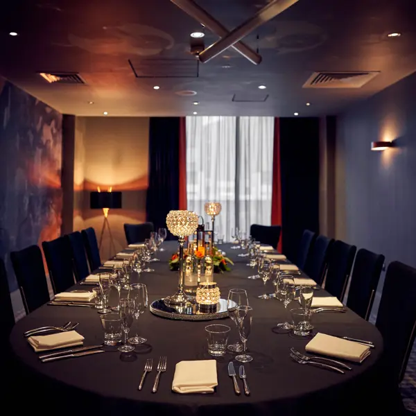 Table arranged for a formal dinner in an elegant room.