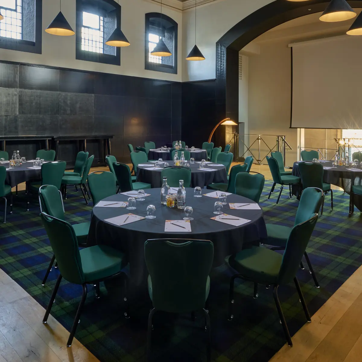 A spacious room featuring a lengthy table adorned with vibrant green chairs.