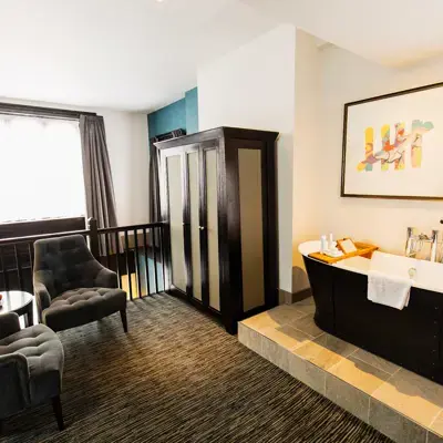 A bathroom featuring a bathtub and a chair.