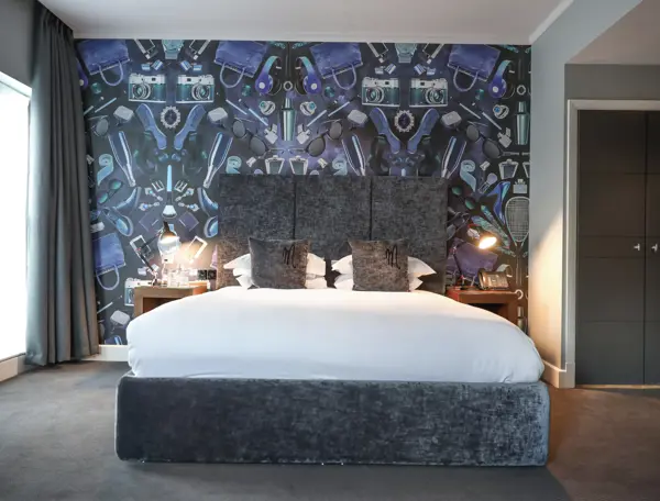Spacious bedroom featuring a king-sized bed and an elegant wall painting.
