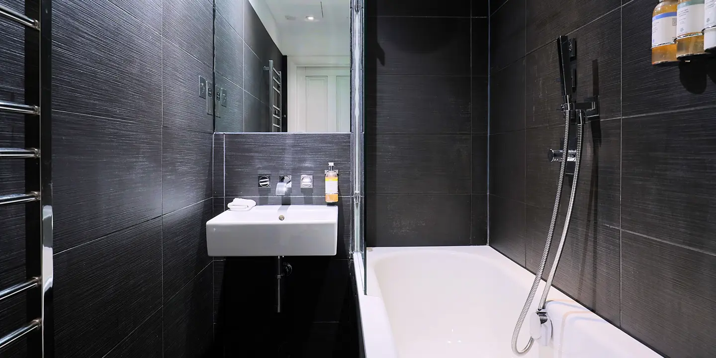 Monochrome bathroom featuring a sink and bathtub.