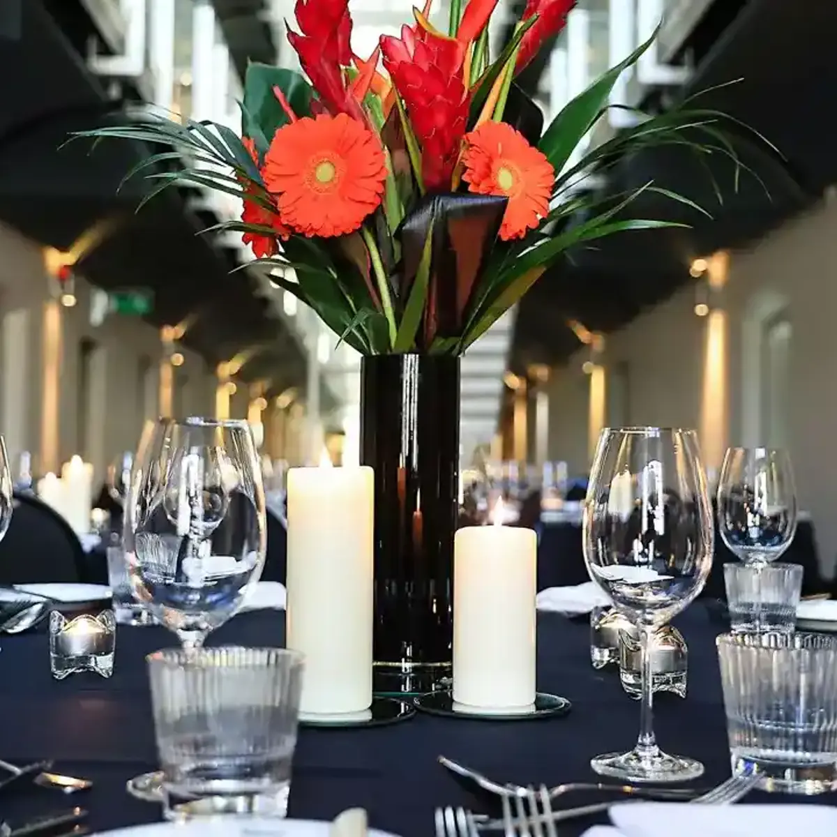 A table adorned with a vase filled with flowers and accompanied by flickering candles.